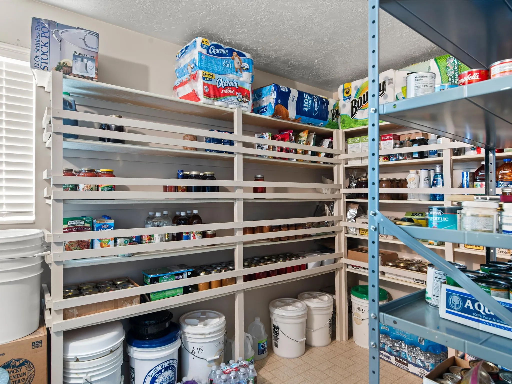 Spacious pantry featuring extensive built-in shelving, additional metal rack shelving, and ample storage capacity