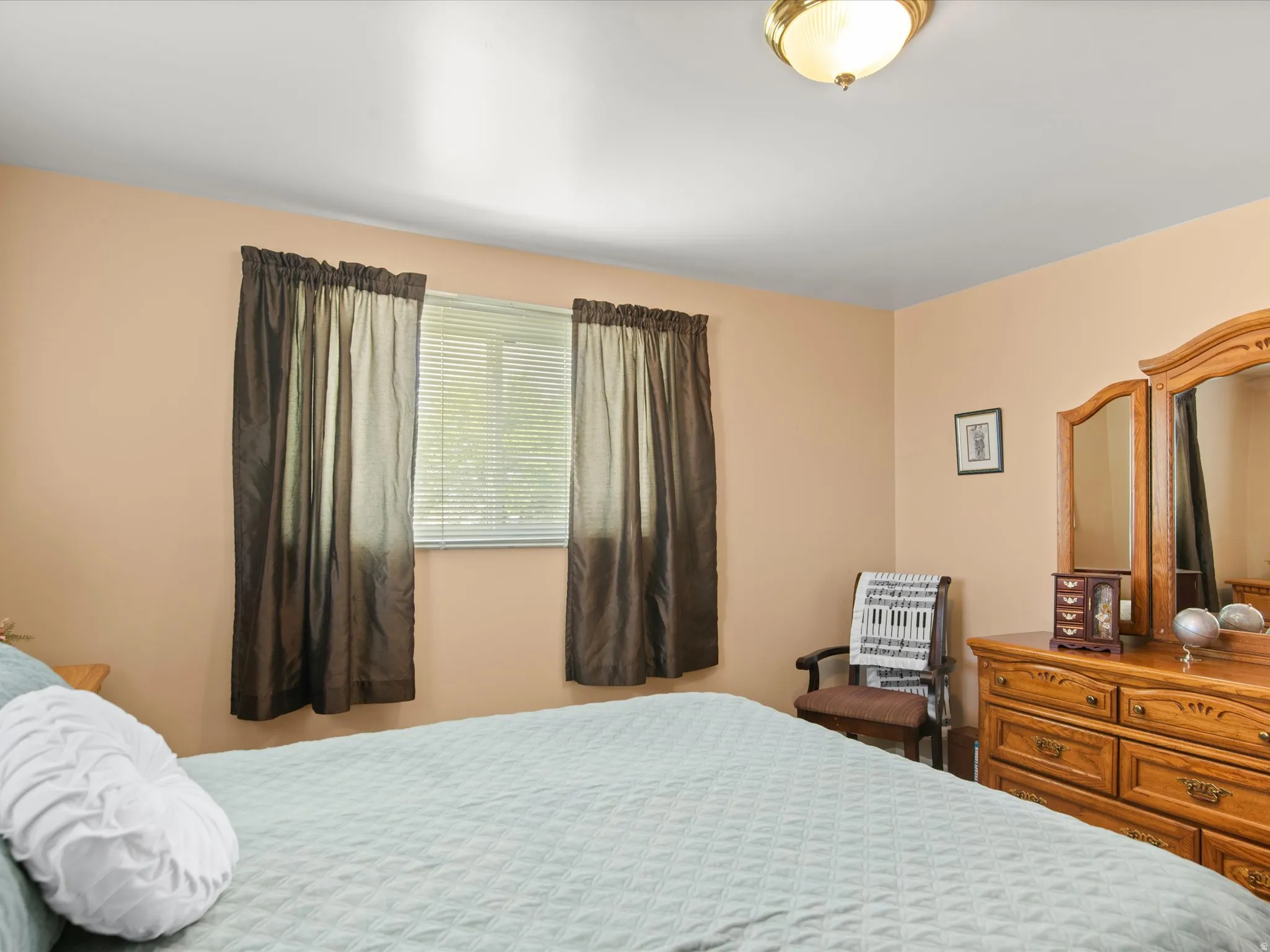 Room with beige walls, a window with blinds, and a flush mount light fixture