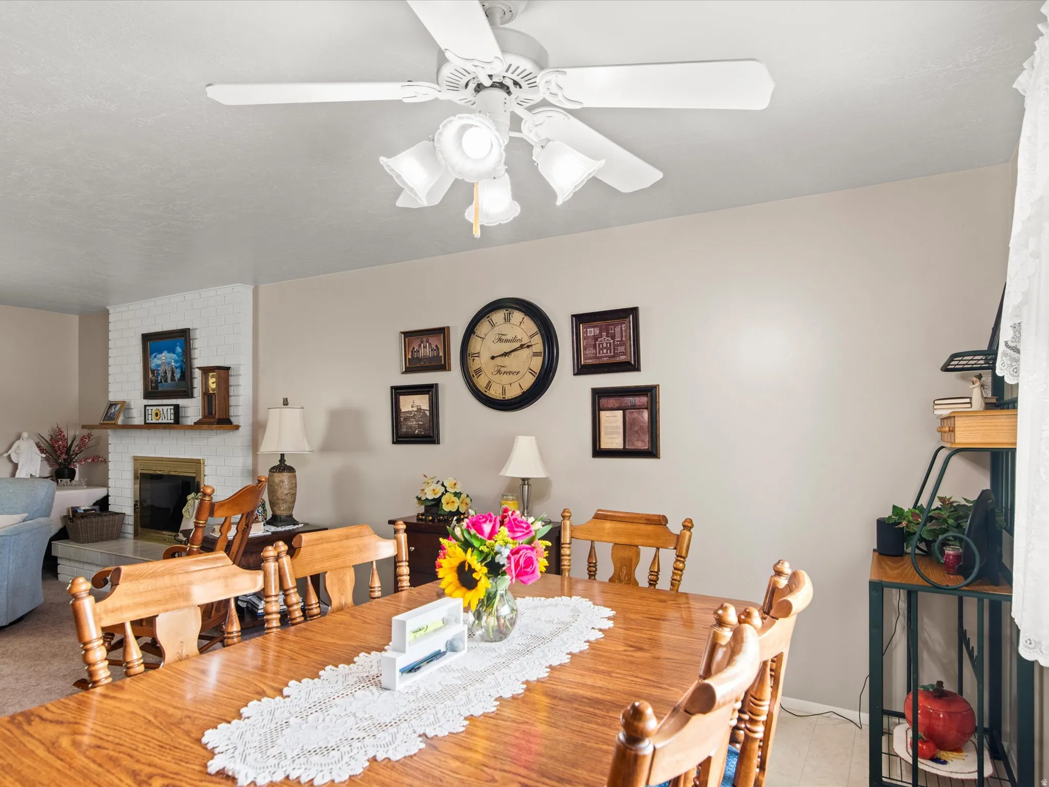 Dining area featuring a wood-finish table, white ceiling fan with integrated lighting, and neutral wall paint