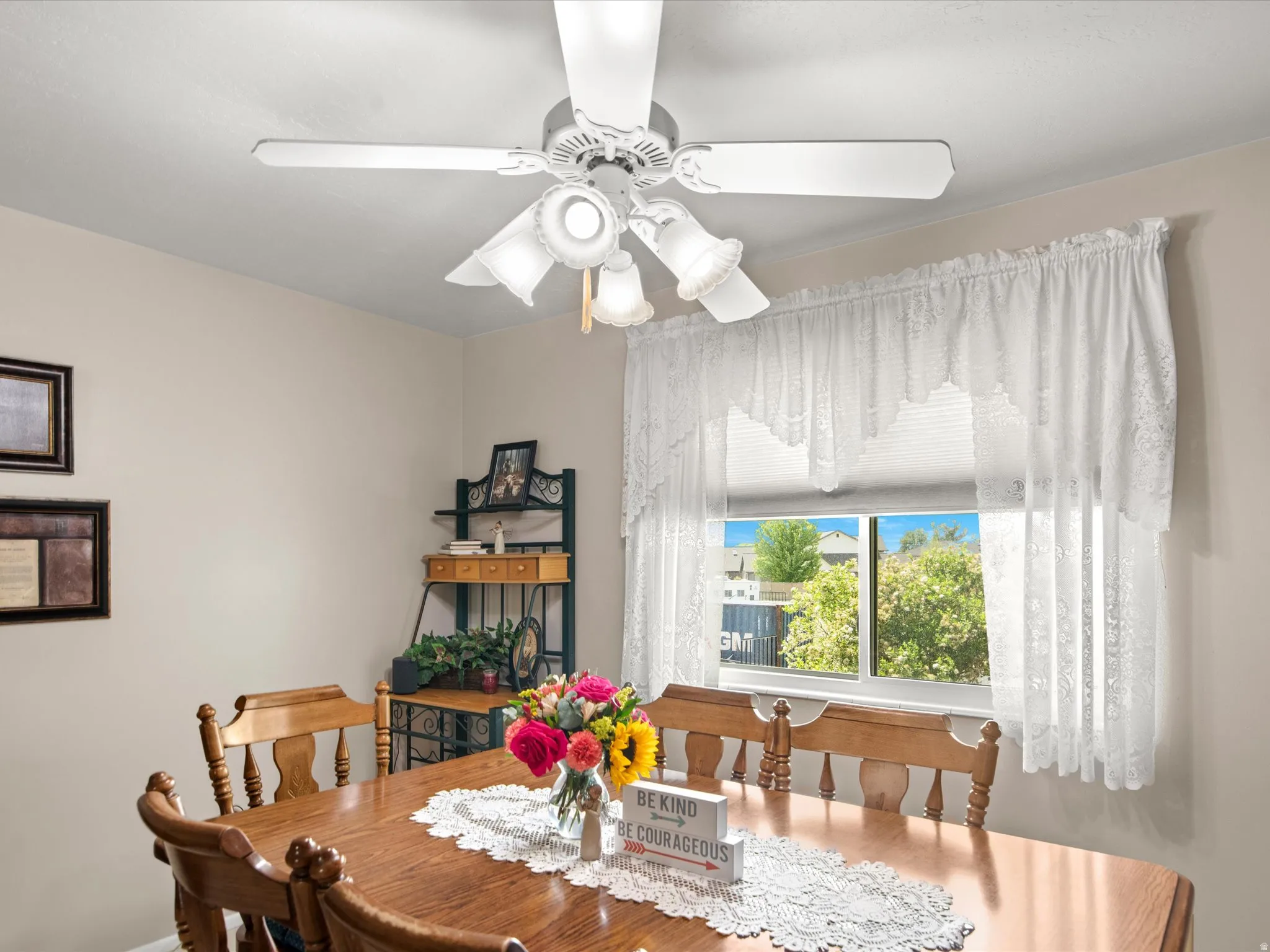 Ceiling fan light fixture illuminating the space, with neutral wall paint and a window providing natural light