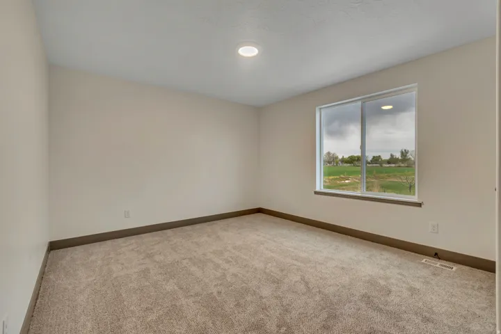 Carpeted spare room featuring baseboards