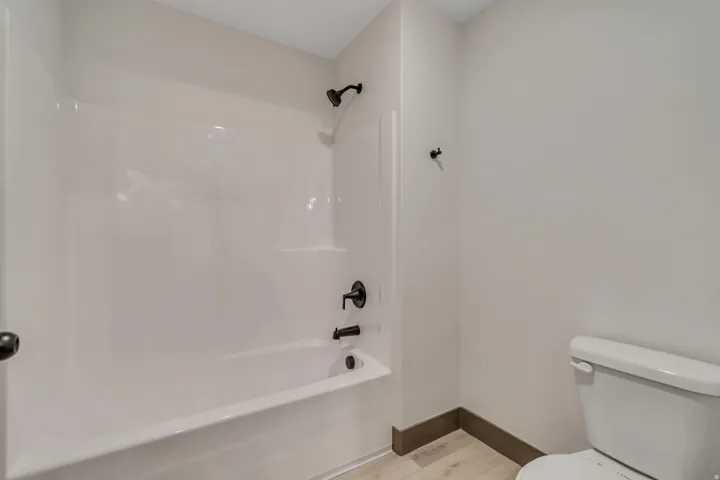 Full bath featuring light wood-style flooring and washtub / shower combination