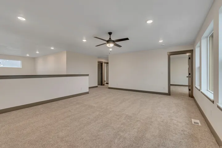 Empty room featuring recessed lighting, ceiling fan, and light colored carpet