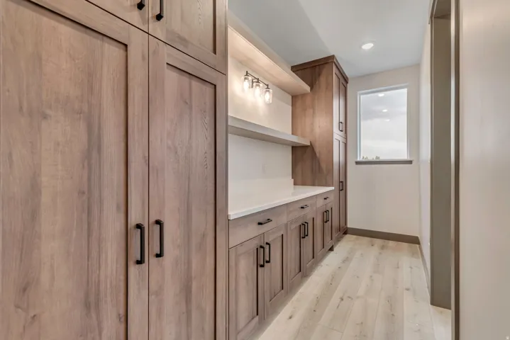 Bar area featuring wood finish cabinets, light wood finished floors, open shelves, and recessed lighting