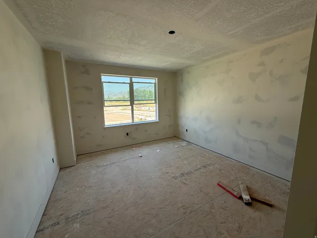 New construction interior with a large window and uninstalled subfloor