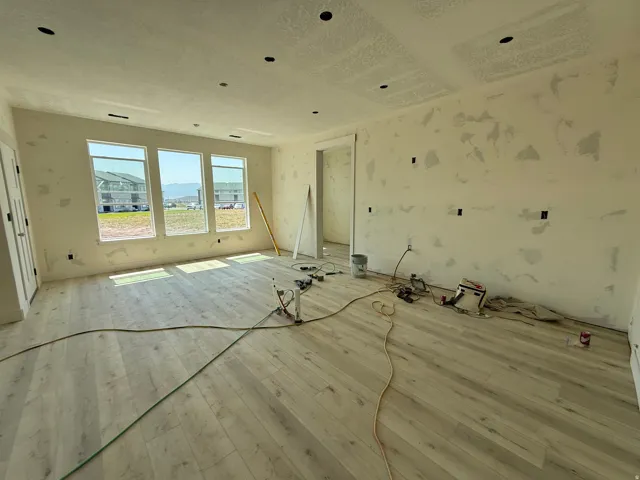 Wood-finish flooring, recessed ceiling lighting, three expansive windows, and a panel door