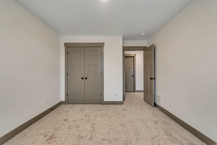 Unfurnished bedroom featuring carpet and a closet