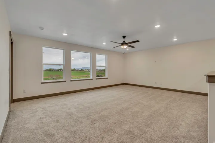 Unfurnished room featuring light colored carpet, a ceiling fan, and recessed lighting