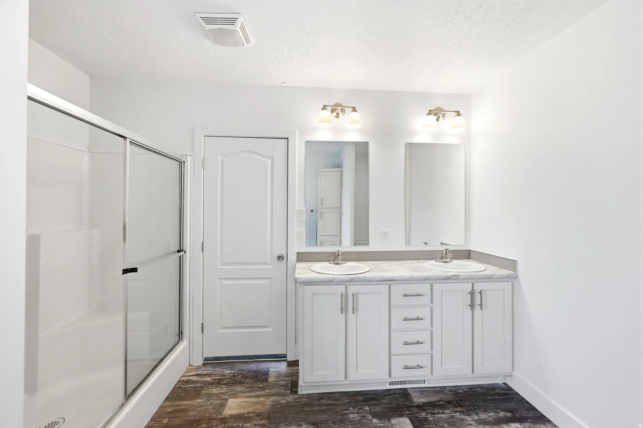 Double vanity with white cabinetry, dual undermount sinks, and individual mirrors