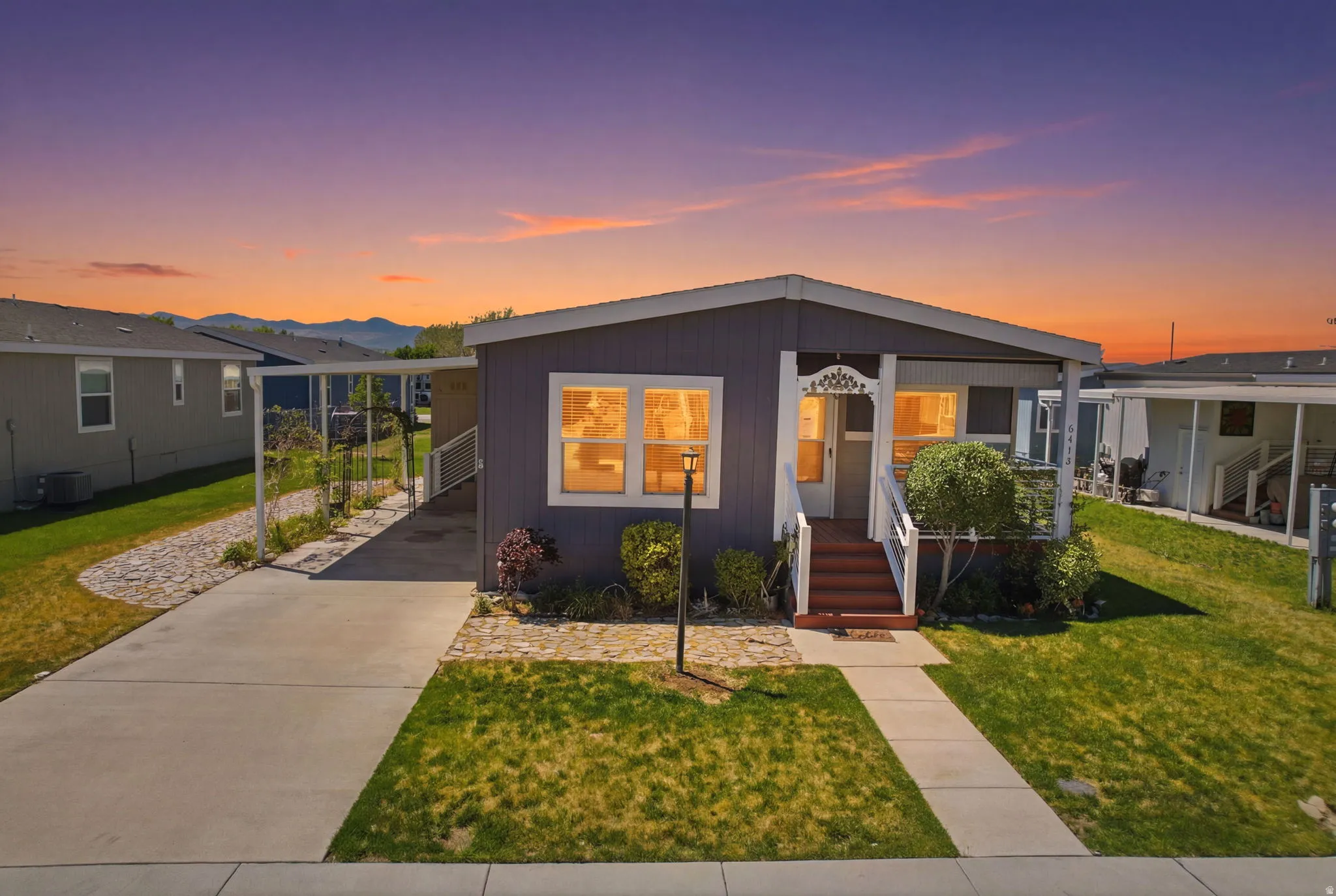Single-story residence featuring a gray exterior with white trim and a covered front porch with white railing