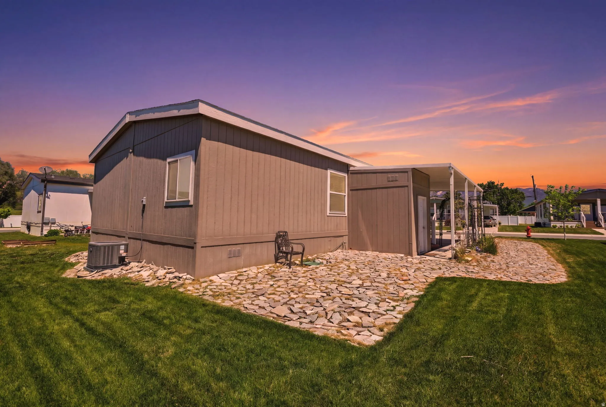 Exterior siding in a neutral tone with white trim, featuring multiple windows