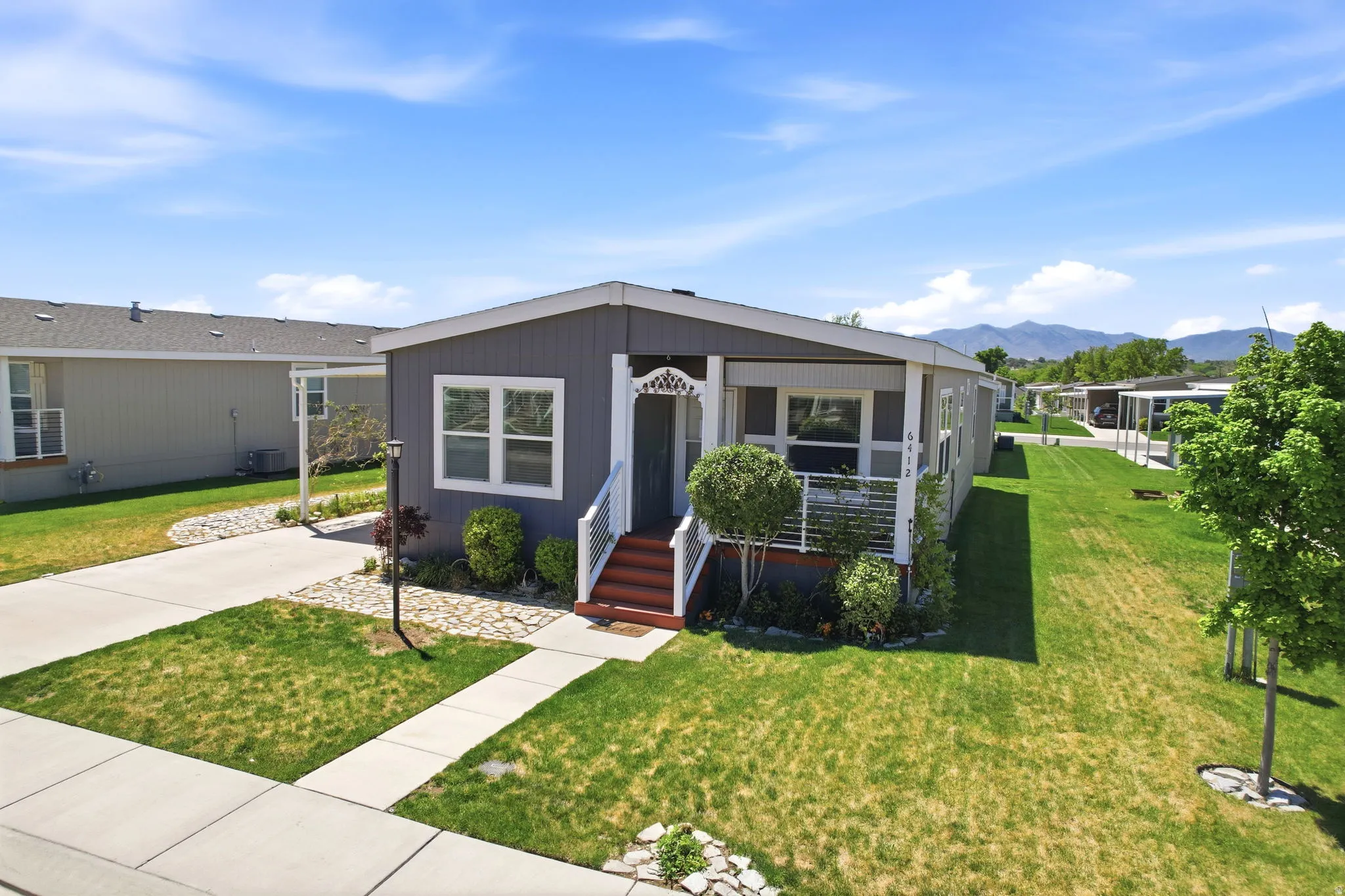 Single-story residence featuring a gray exterior with white trim and a covered front porch with white railings
