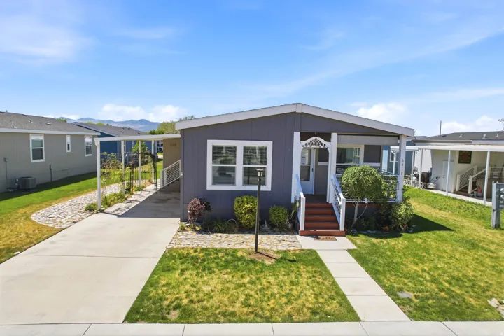 Gray exterior with white trim and a covered front porch featuring white railings