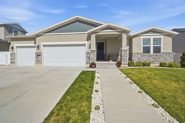 Contemporary stucco exterior with stone accents and a covered front entry