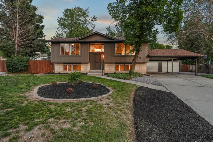 Split-level residence featuring a brown siding facade with brick accents and a brown front door