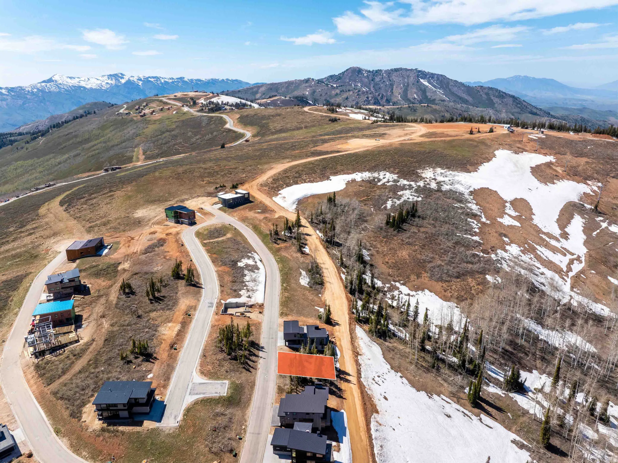 Expansive mountain landscape featuring multiple custom residences and winding roads