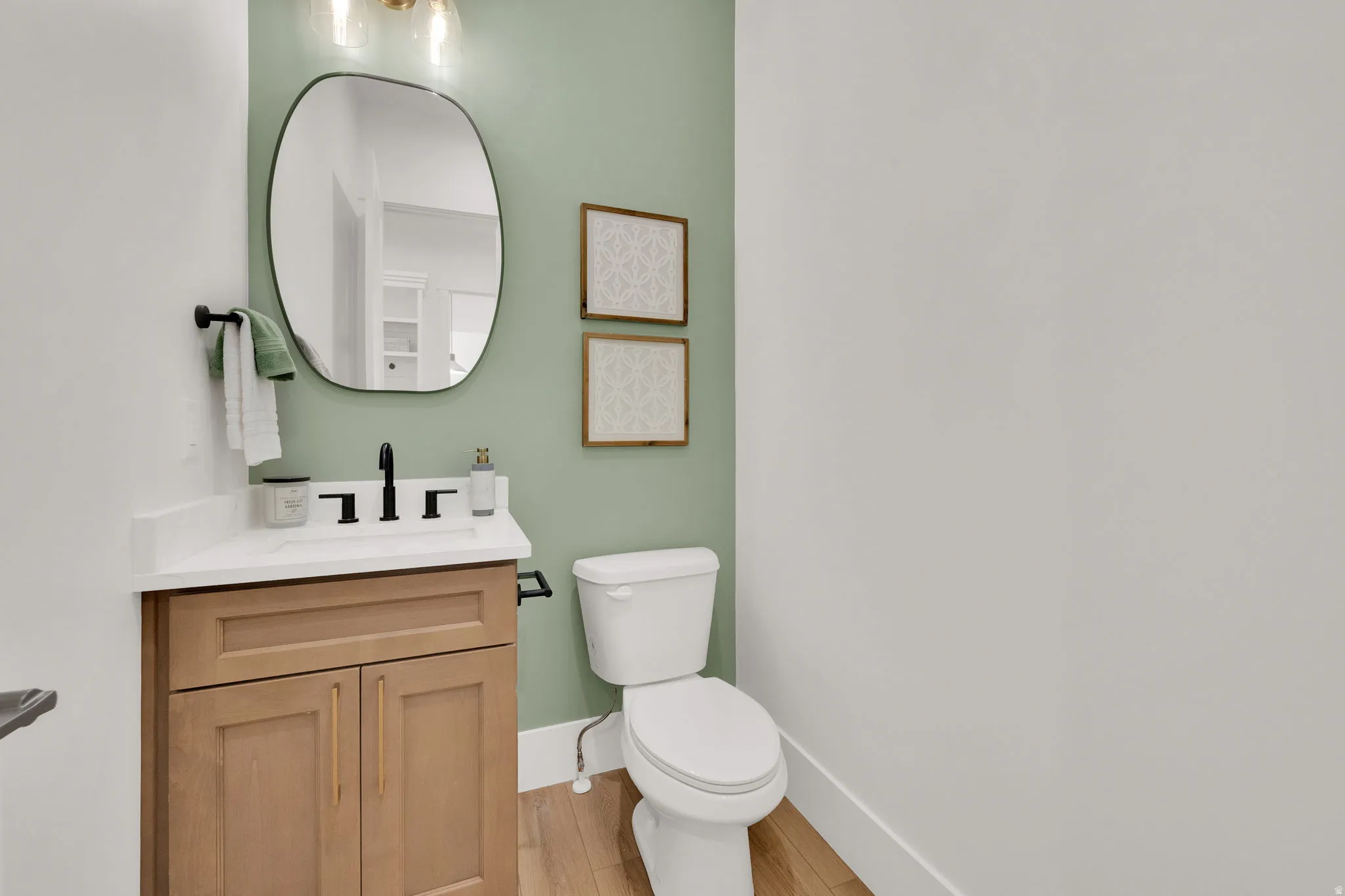 Powder room featuring a wood-finish vanity with a white countertop and rectangular sink