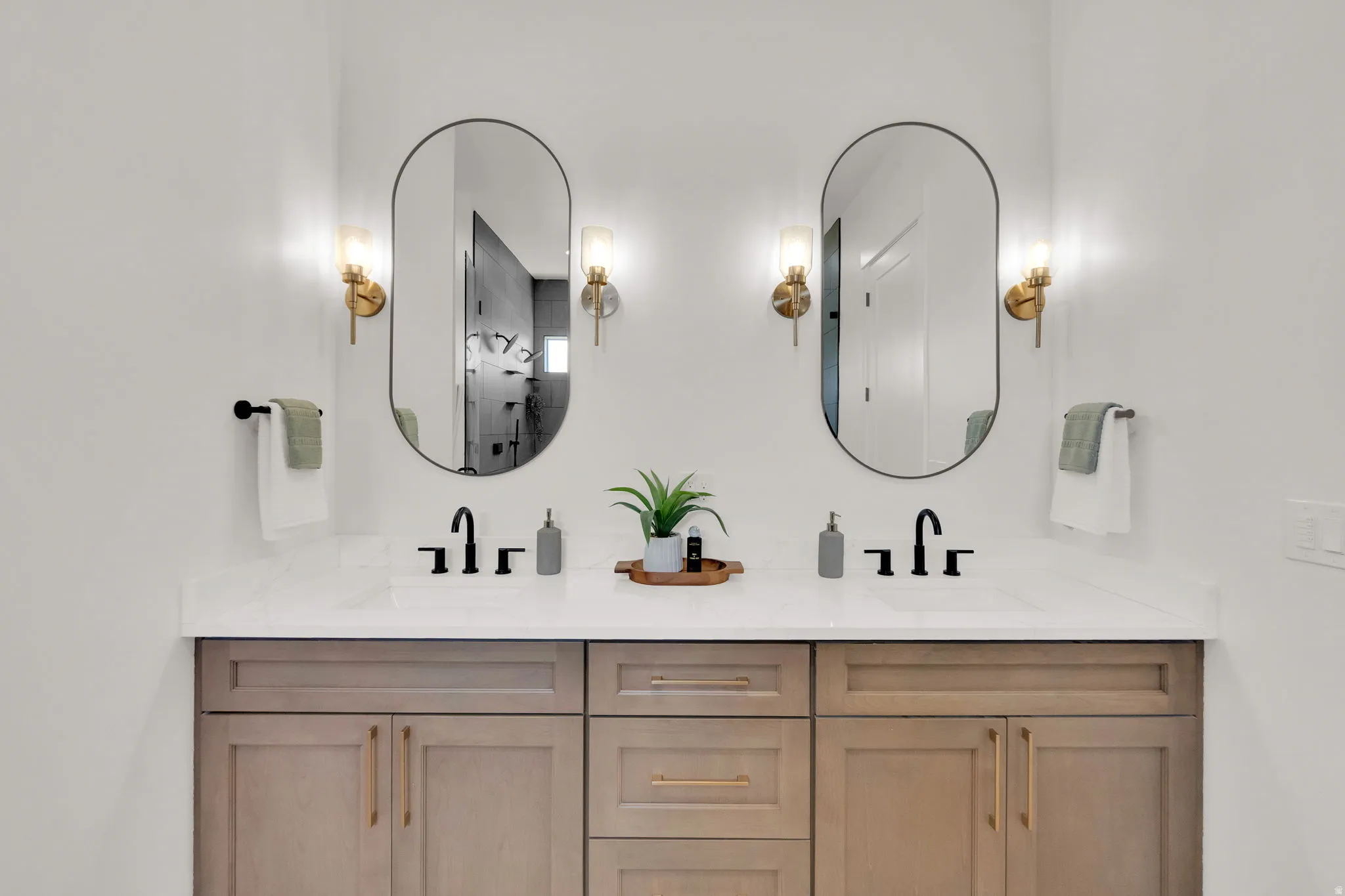 Dual vanity with wood-finish cabinetry, white countertop, and integrated sinks