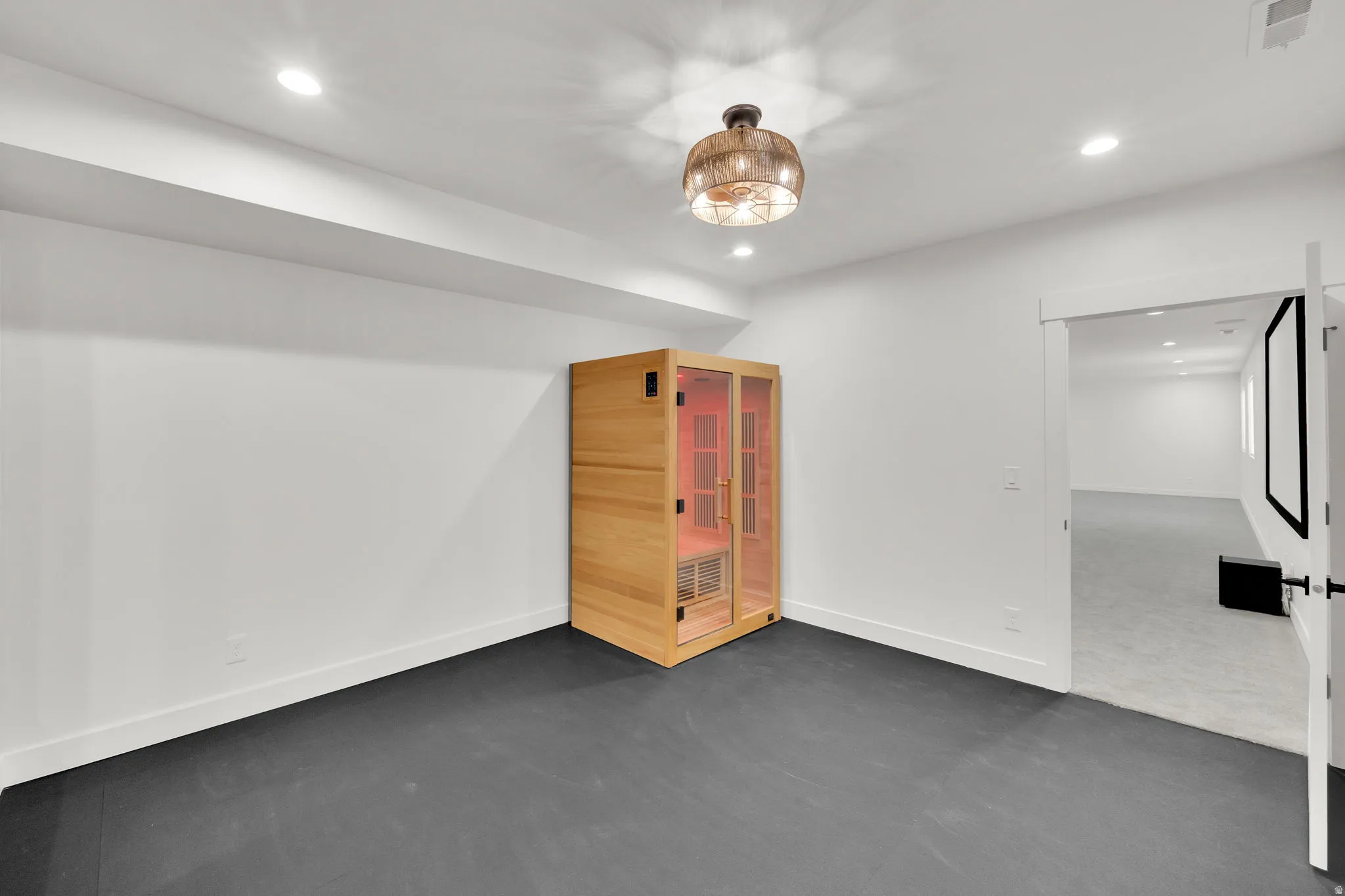Spacious room with dark gray flooring and a built-in wood-paneled sauna