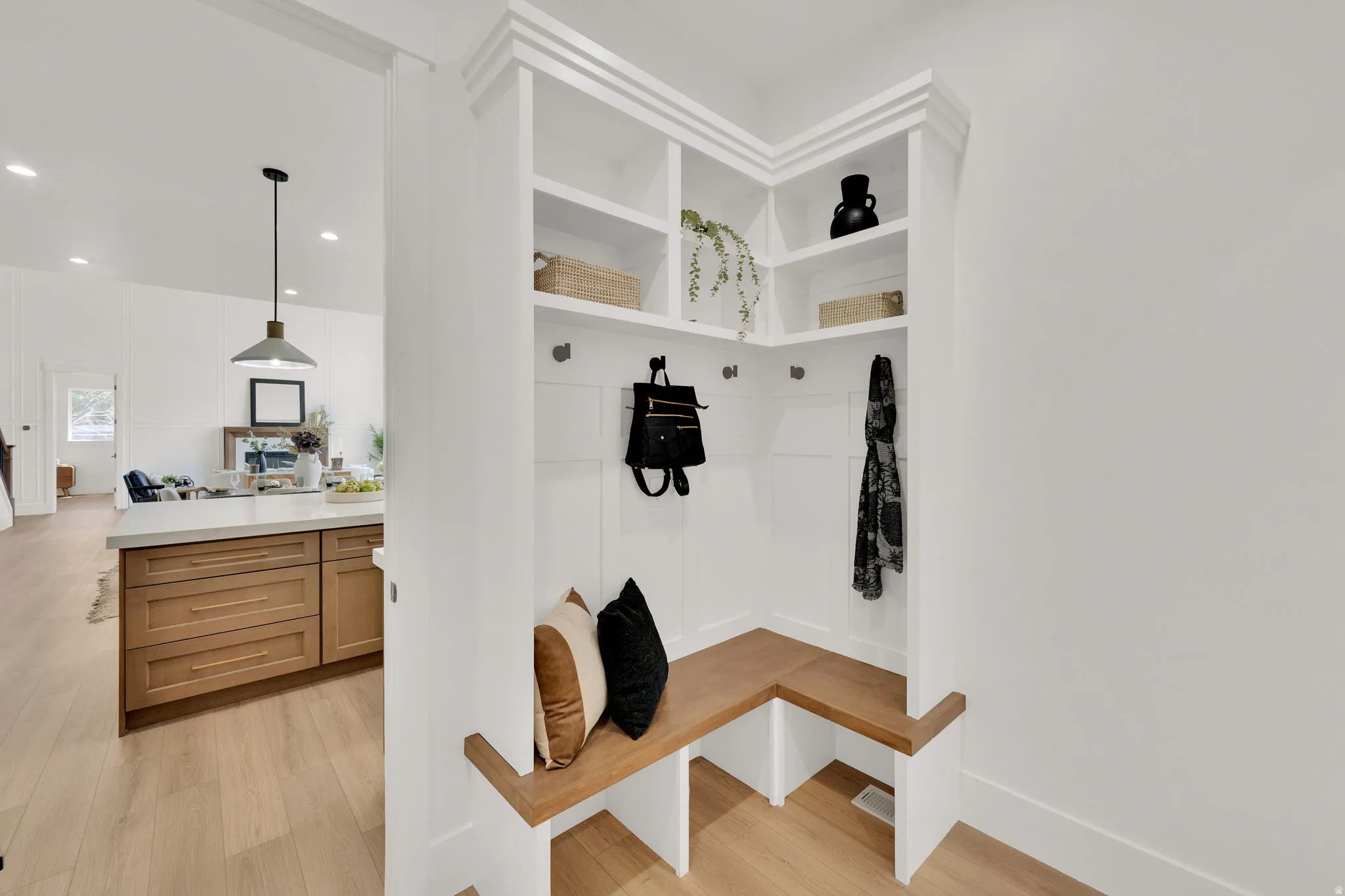 Built-in mudroom bench with natural wood finish, integrated storage cubbies, and overhead shelving
