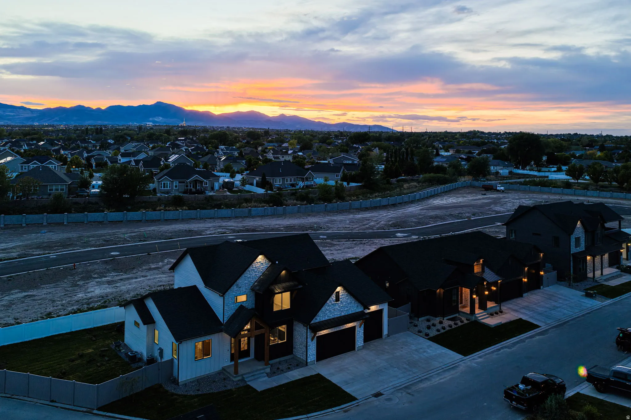 Modern residential architecture featuring dark roofing, light-colored siding, and stone accents