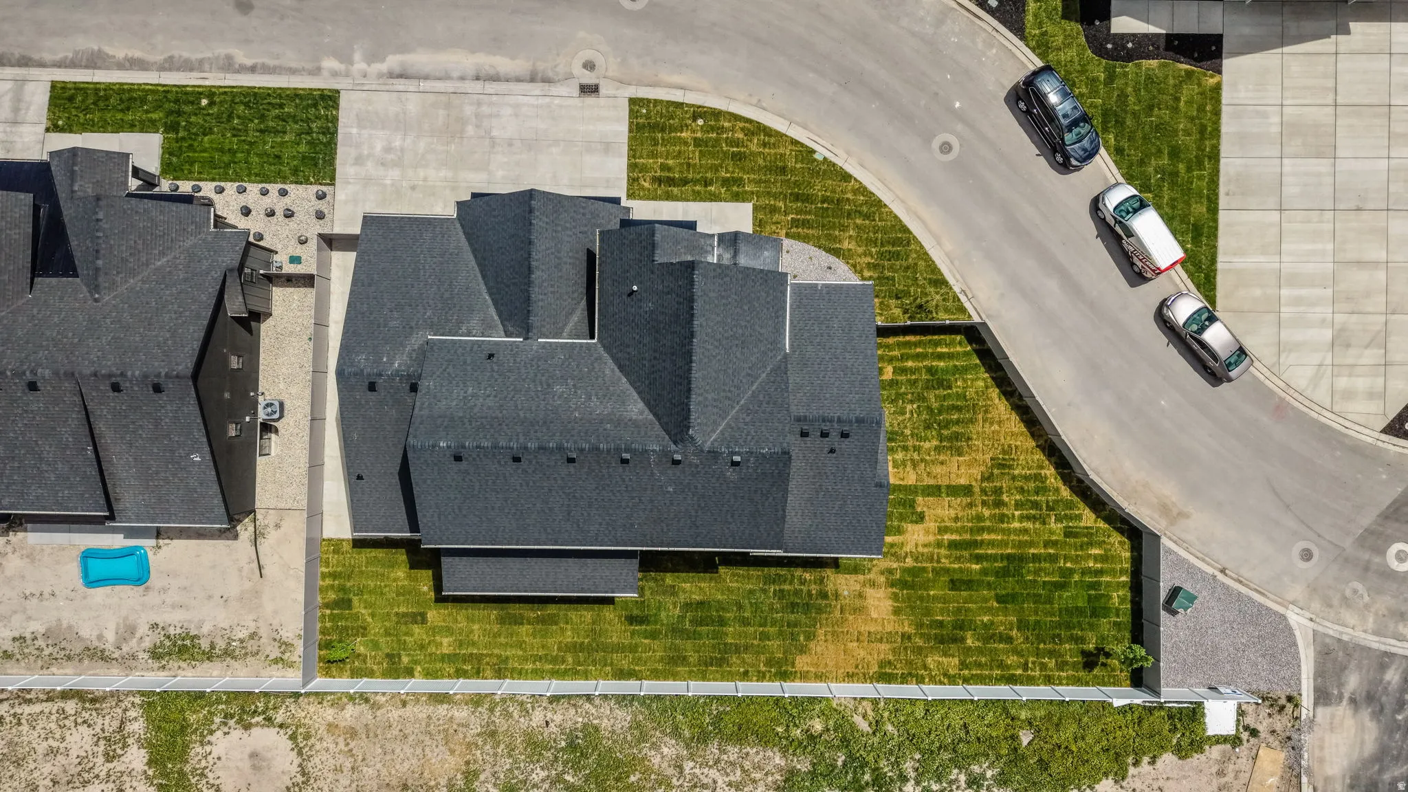 Aerial perspective highlighting the property's roofline, surrounding green spaces, and paved street access