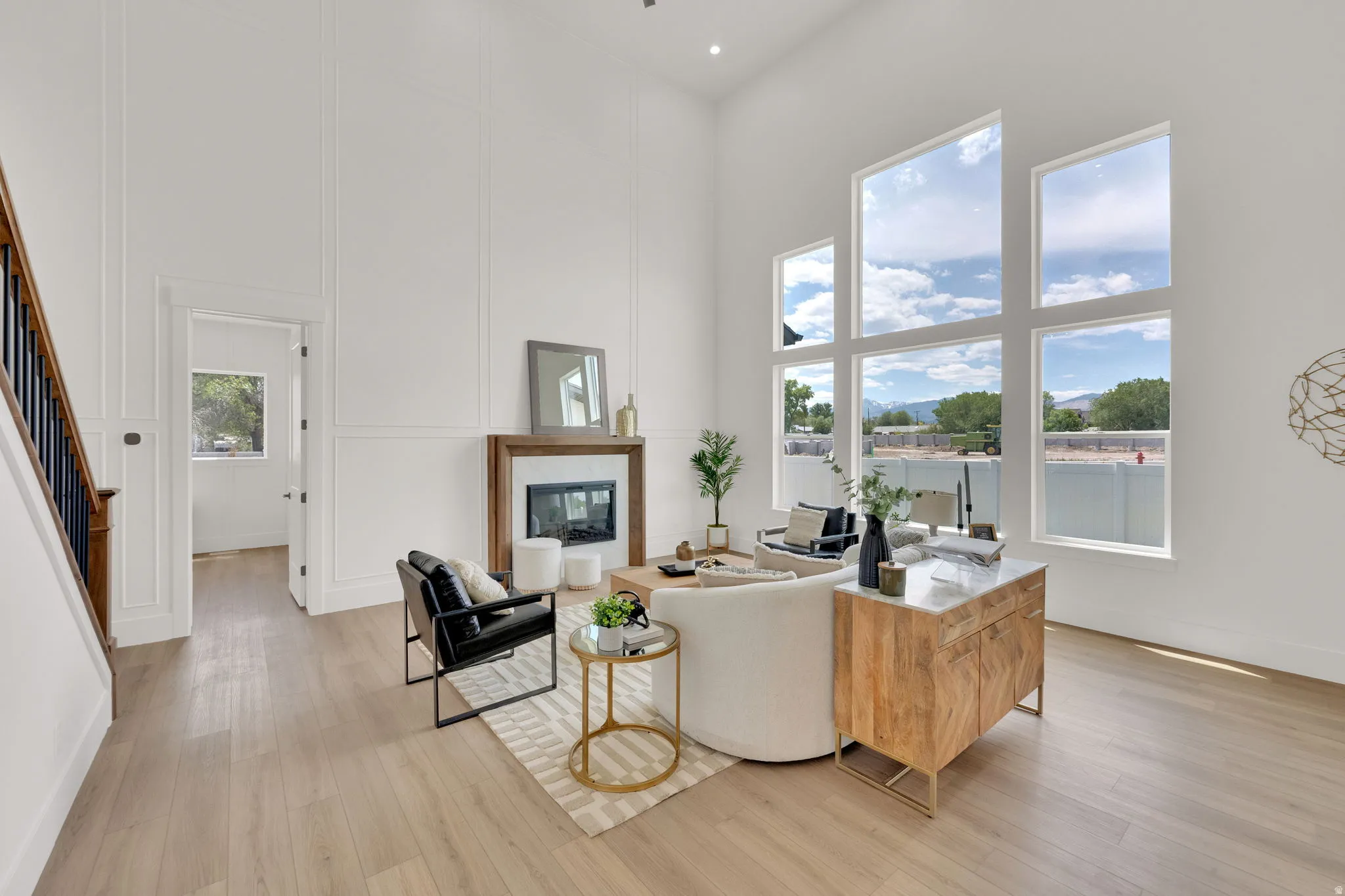Great room featuring high ceilings, a fireplace with a wood surround, and extensive window walls