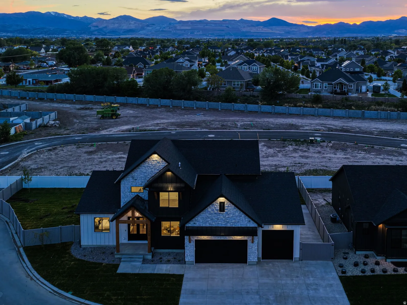 Contemporary-style residence featuring a dark-toned roof, stone and horizontal siding exterior, and a two-car garage