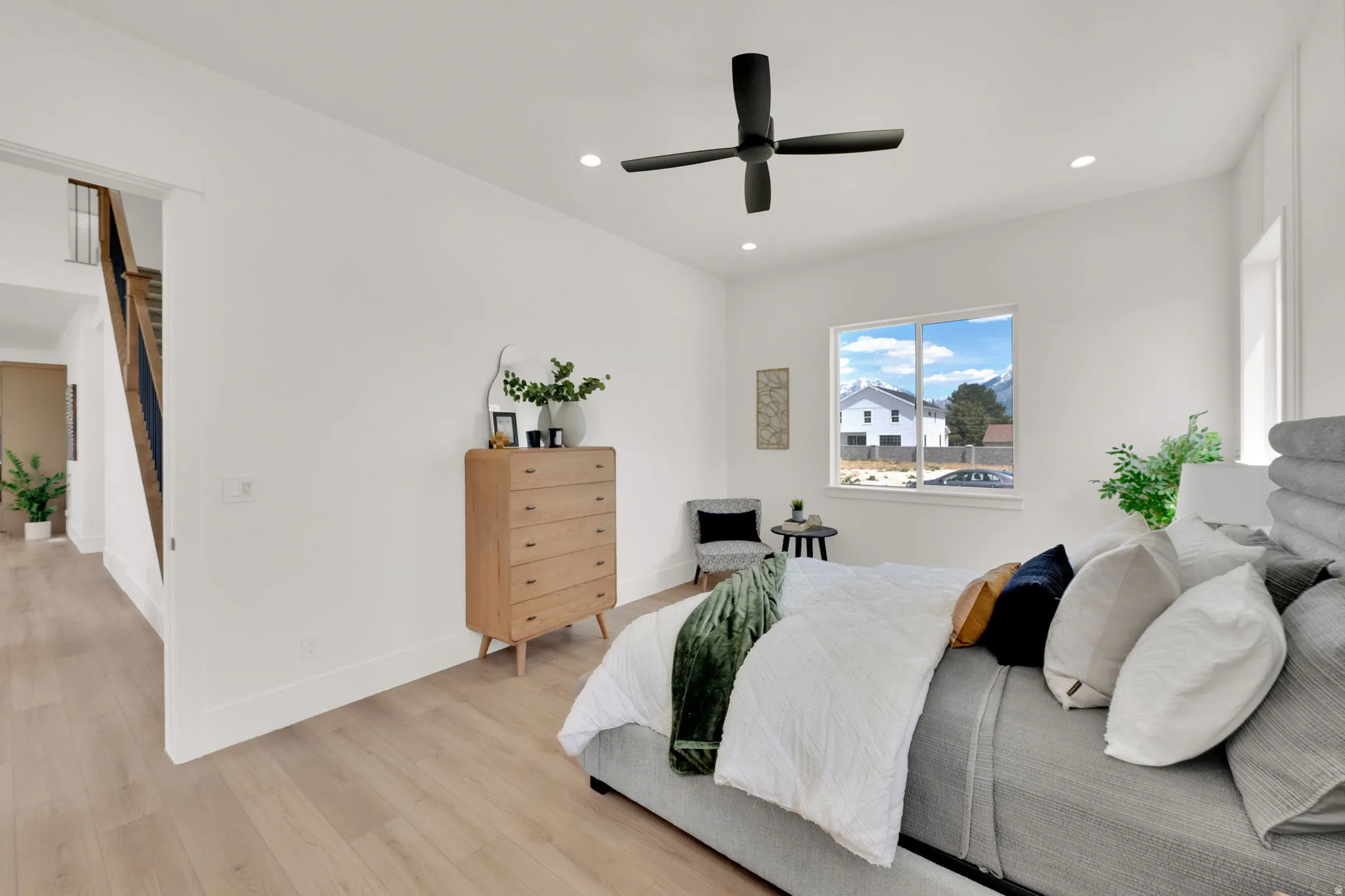Spacious room featuring wood-finish flooring, a contemporary ceiling fan, and recessed lighting
