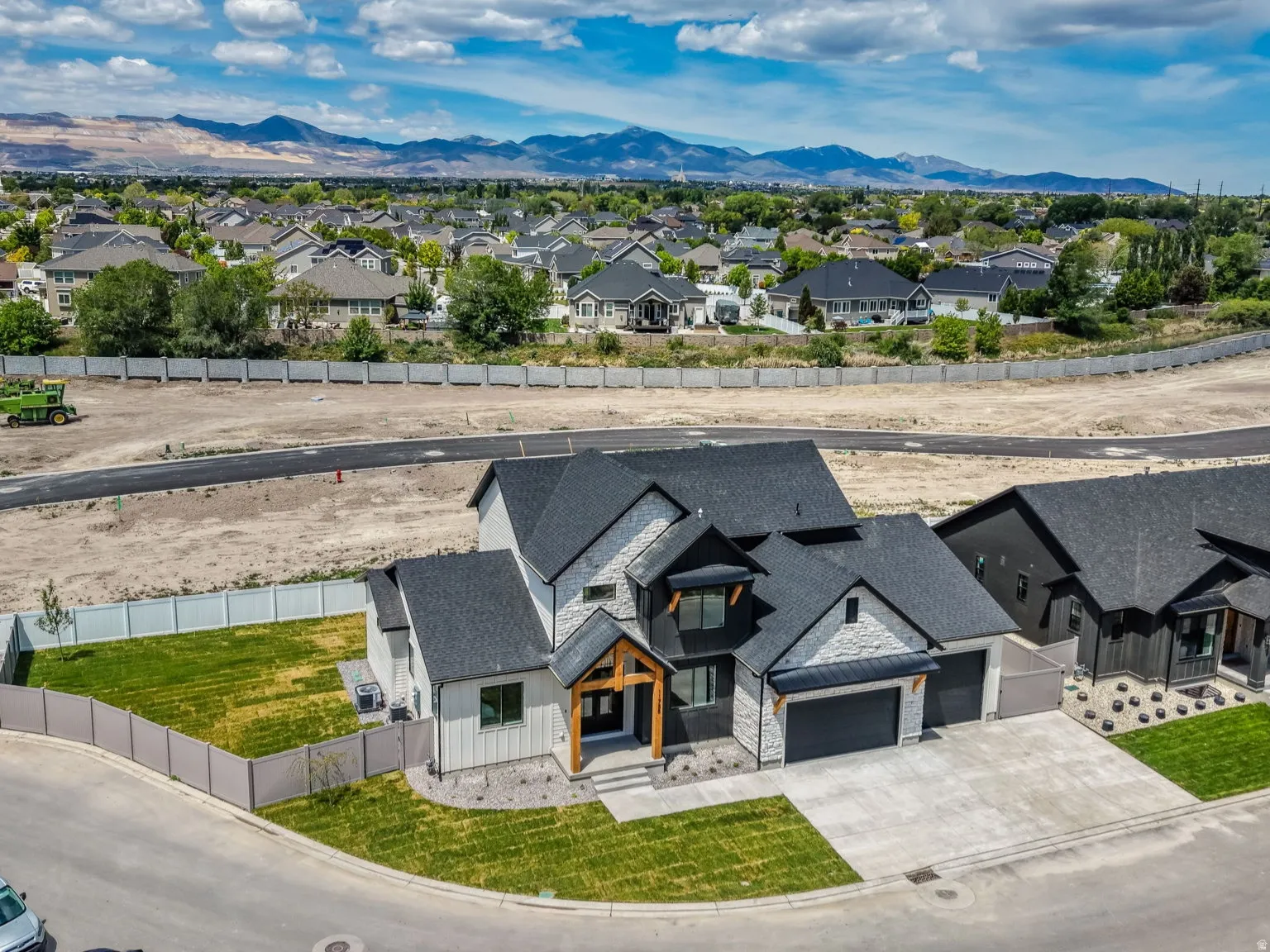 Newly constructed home featuring a modern facade with stone and vertical siding accents