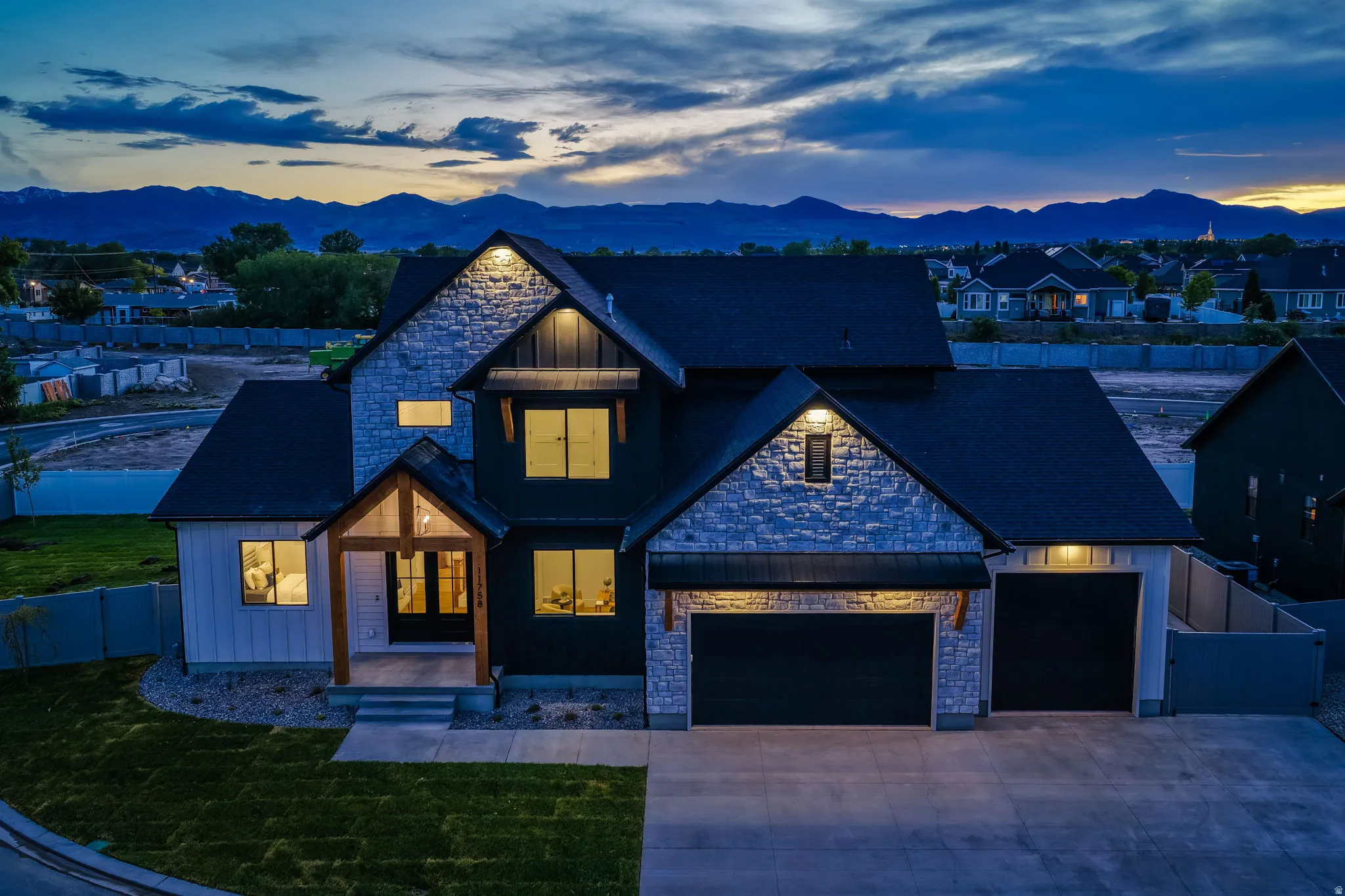 Modern farmhouse-style home with prominent stone and horizontal siding accents