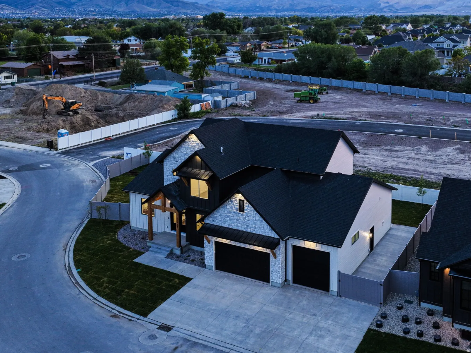 Modern architectural style featuring dark siding, light stone accents, and a multi-gabled roofline