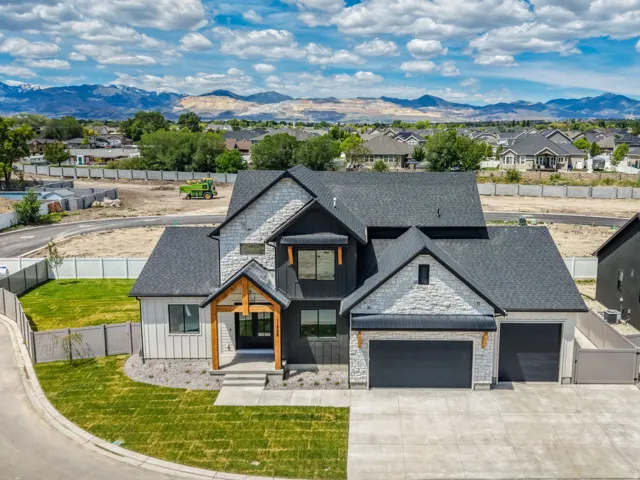 Contemporary-style residence featuring a distinctive facade with stone veneer, vertical siding, and a dark shingle roof