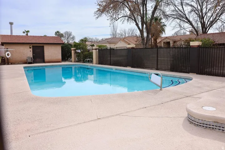 Outdoor swimming pool featuring a curved design and a concrete surround