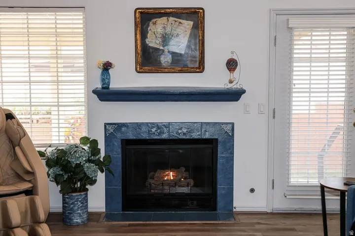 Fireplace with blue-tiled surround and hearth, featuring a dark metal firebox