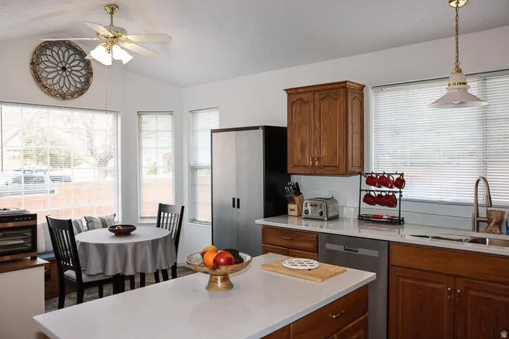 Open-concept kitchen with white countertops and wood-finish cabinetry