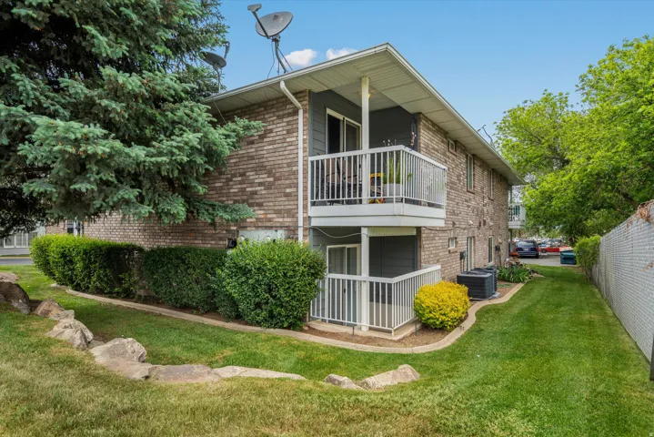 Brick-sided structure featuring private balcony with white railings