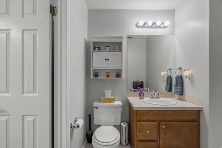 En suite 1/2 Bathroom featuring a wood-finish vanity with a light-toned countertop and sink