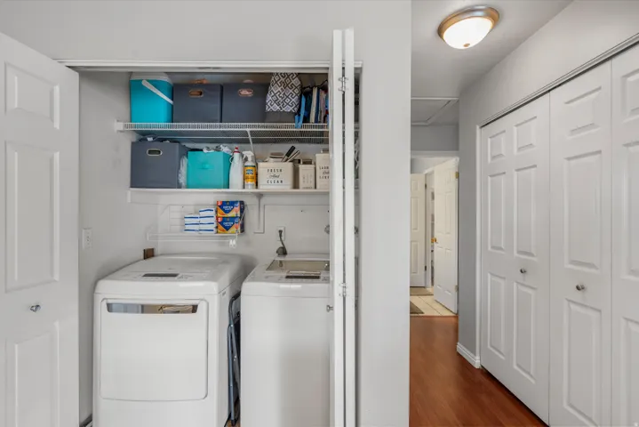 Dedicated laundry closet featuring a built-in top shelf, a wire rack, and bi-fold doors