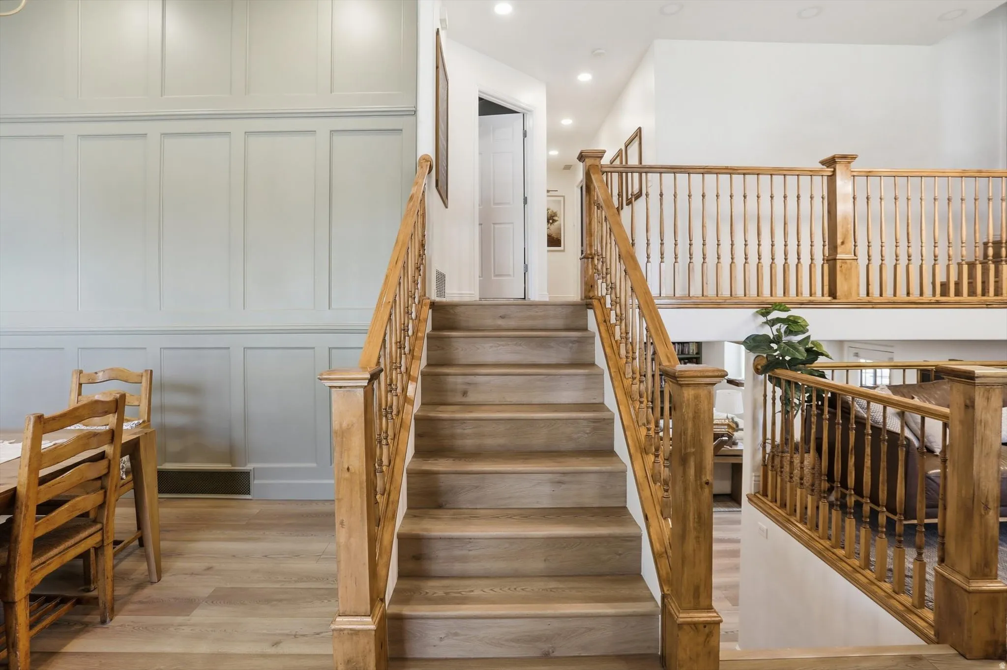 Staircase with light wood treads and natural wood balustrade and handrail