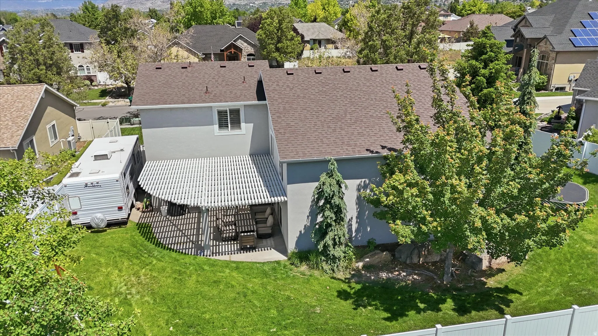 Rear exterior featuring a covered patio with a slatted roof, providing an outdoor living area