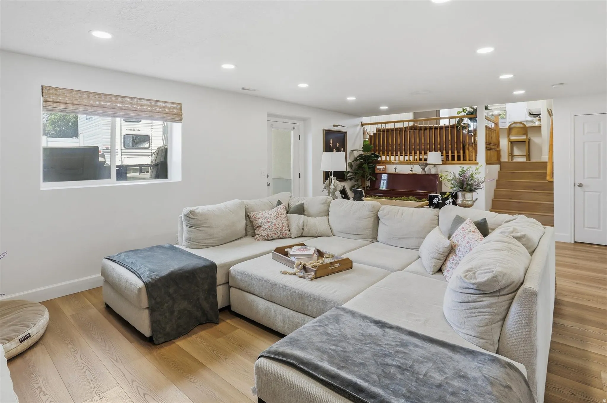 Bright living area featuring wood-finish flooring and recessed lighting