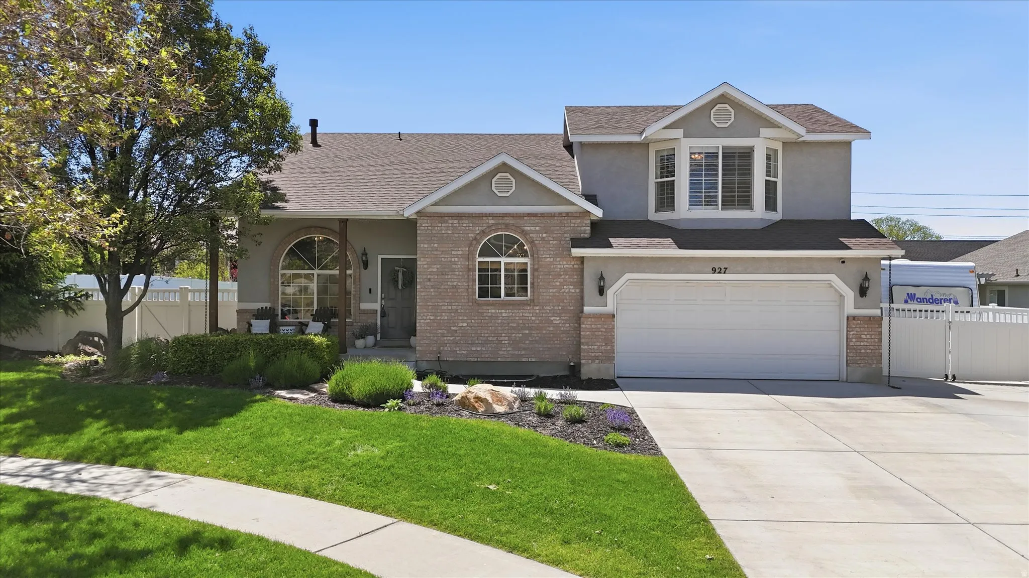 Traditional-style residence featuring a brick facade and light stucco siding