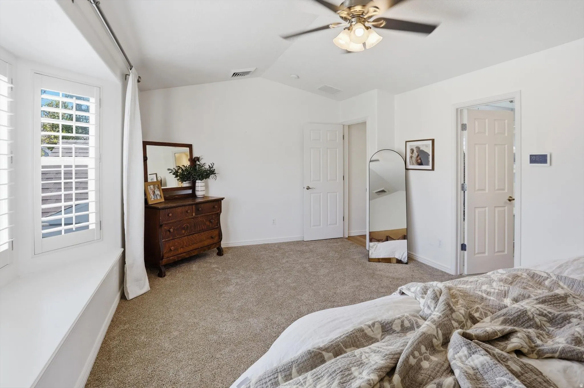 Carpeted room featuring a ceiling fan with integrated lighting, white walls, and bright white trim