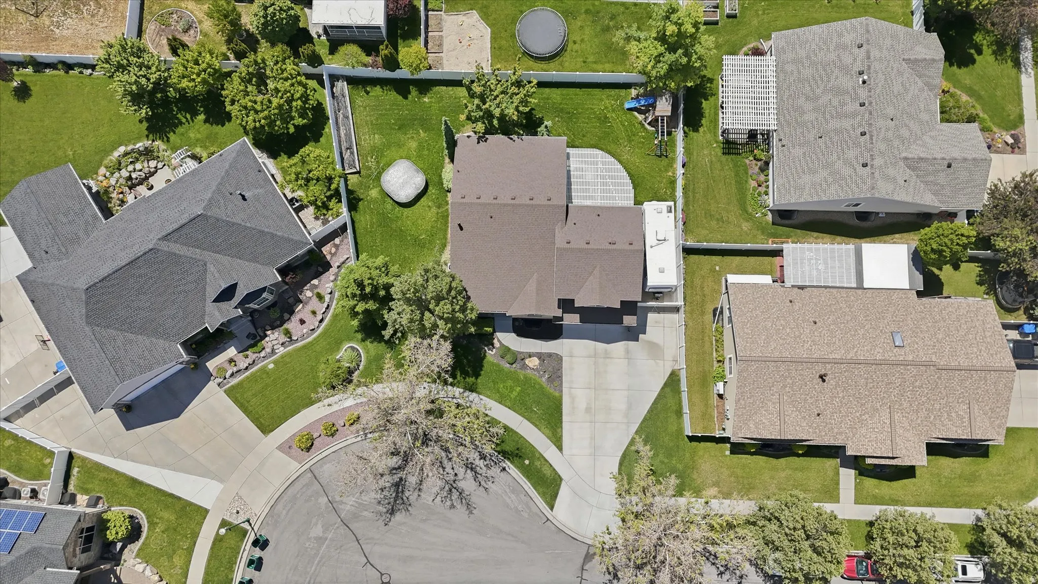 Cul-de-sac property with a multi-level roofline, extensive paved driveway, and manicured landscaping