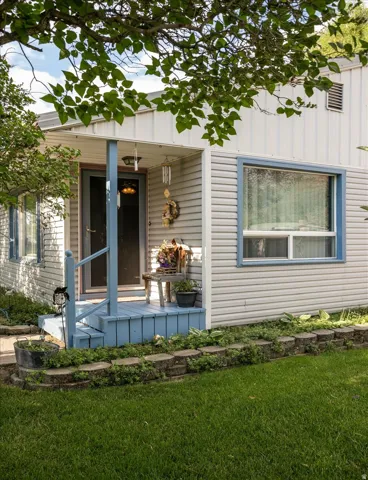 Front entrance featuring a blue-painted wood porch with a matching handrail