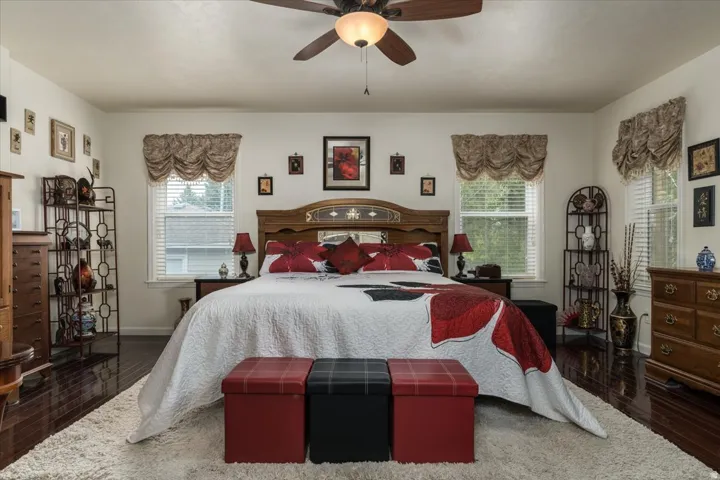 Spacious bedroom featuring dark wood-finish flooring and a neutral color palette