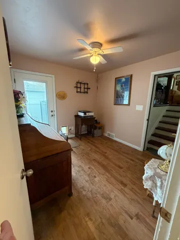 Wood-finish flooring throughout, complemented by a ceiling fan with integrated lighting