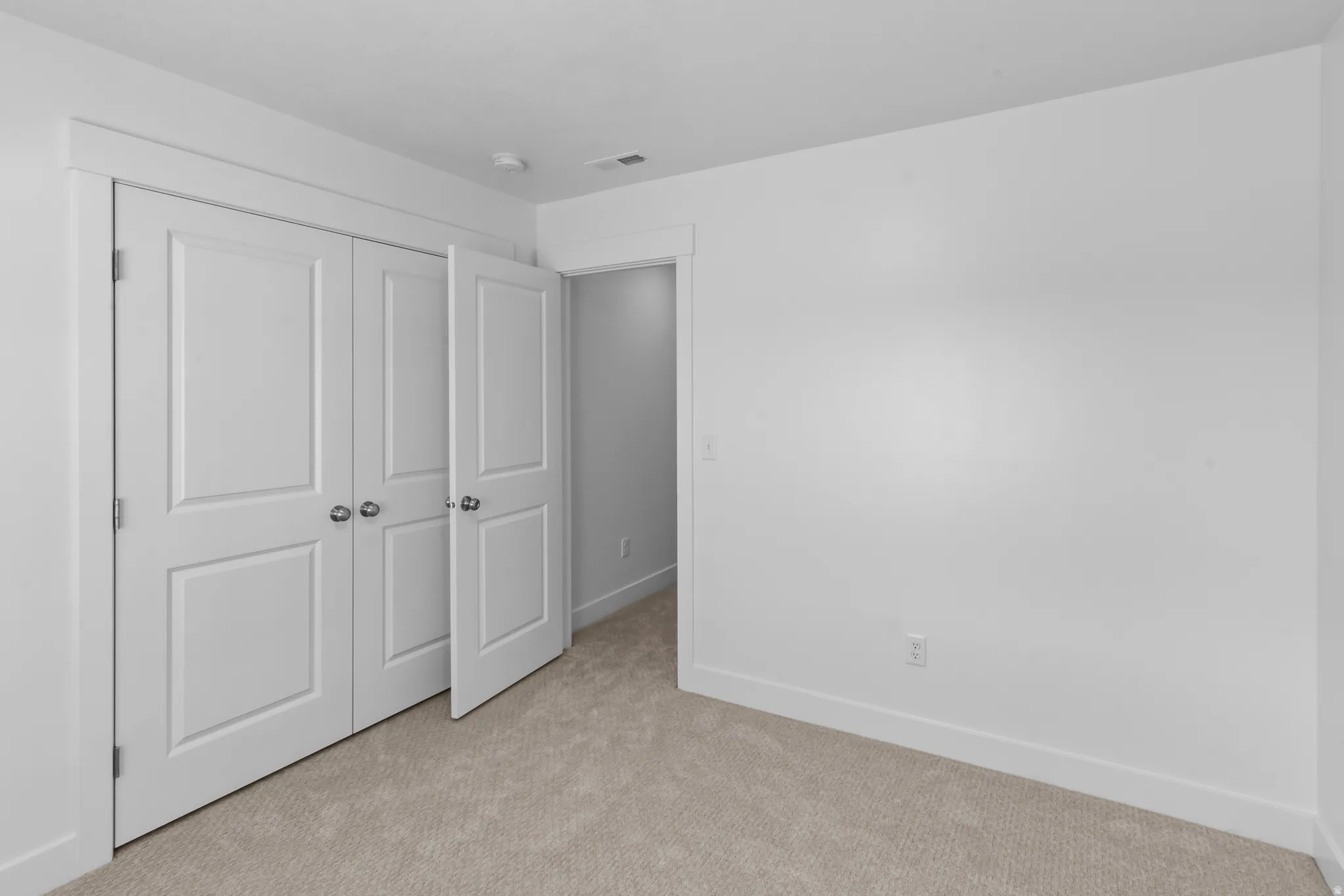 Bedroom space featuring neutral-toned carpeting and white walls