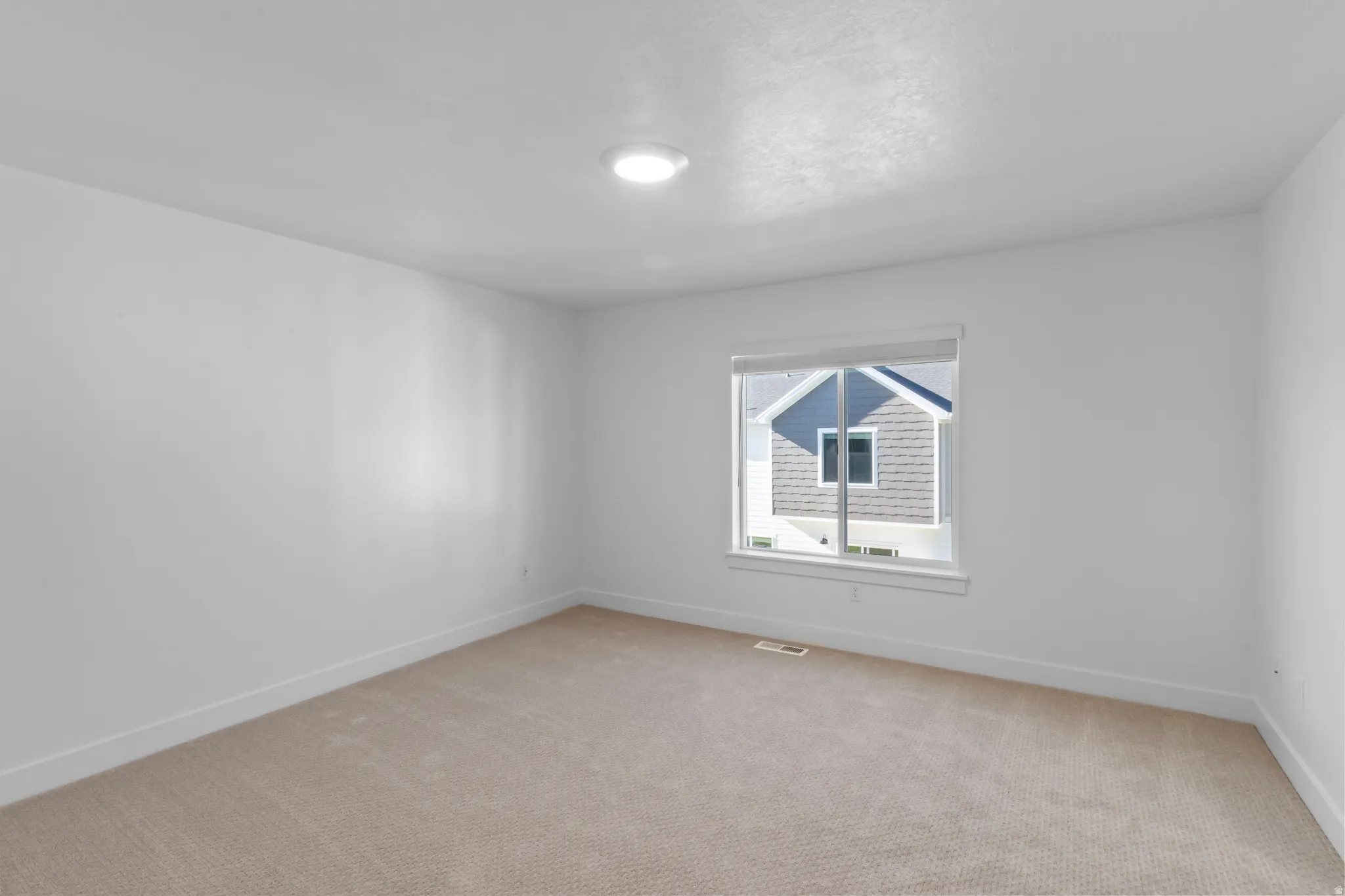 Neutral color palette featuring light-toned carpeting and bright white walls